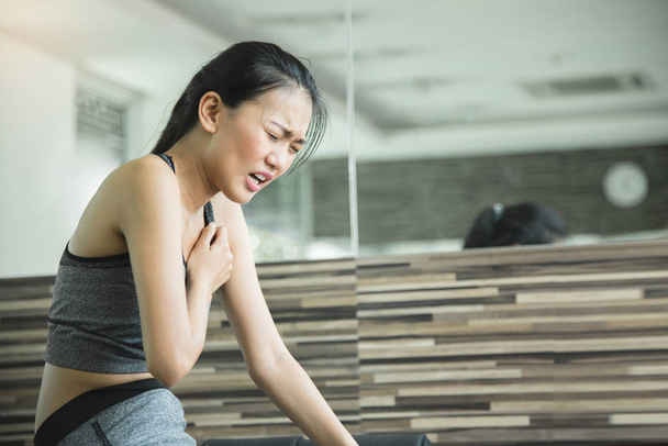 Asian woman having heart attack after workout. - Foto, Imagen