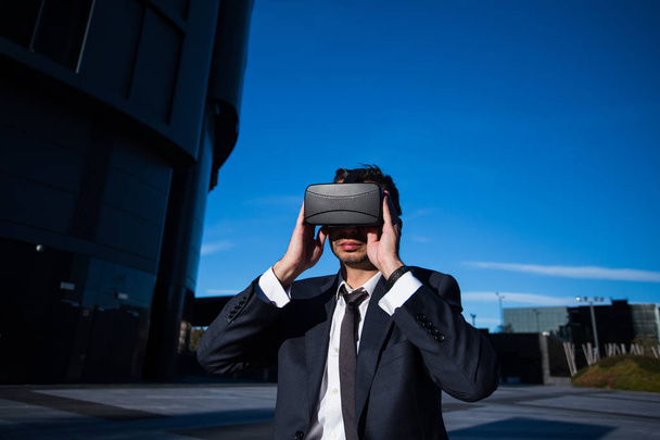 Businessman adjusting his virtual reality glasses - Photo, Image