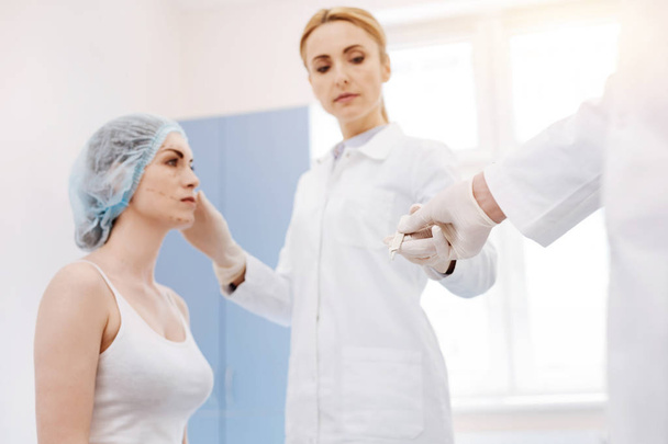 Serious professional surgeon taking a scalpel - Foto, Bild