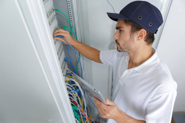 focused electrician applying safety procedure while working on electrical panel - Foto, immagini