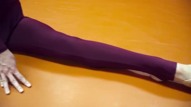 Young gymnast woman stretching on the floor closeup - Filmagem, Vídeo