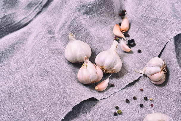 white heads raw garlic on a gray cloth, close up - Foto, afbeelding