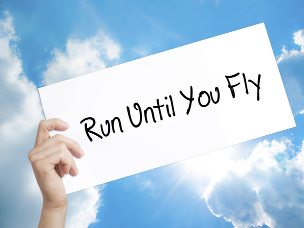 Run Until You Fly Firma en papel blanco. Hombre mano sosteniendo papel w
 - Foto, Imagen