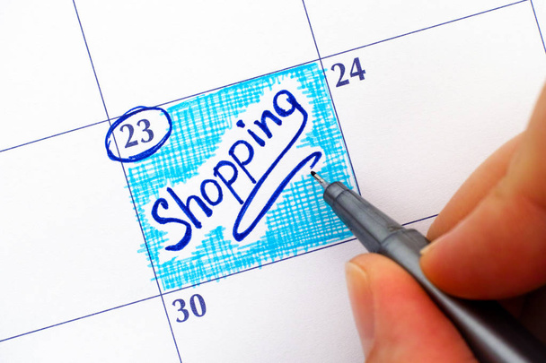 Donna mano con penna scrittura promemoria Shopping nel calendario
. - Foto, immagini