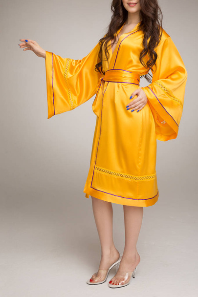Fille en robe de soie jaune, fond gris
 - Photo, image