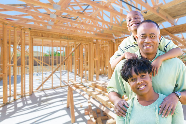 Jonge Afro-Amerikaanse familie op Site binnen hun nieuwe huisbouw Framing. - Foto, afbeelding