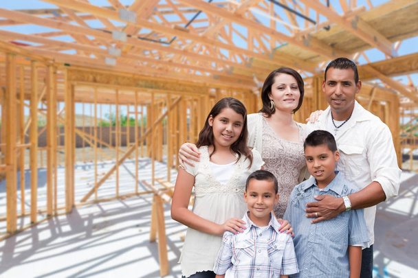 Young Hispanic Family On Site Inside New Home Construction Framing. - Photo, Image