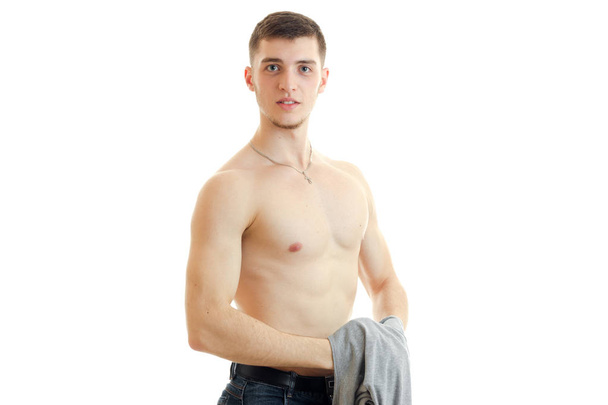 young handsome guy stands with the Bared torso holding a Mike and looks into a camera - Foto, Imagen