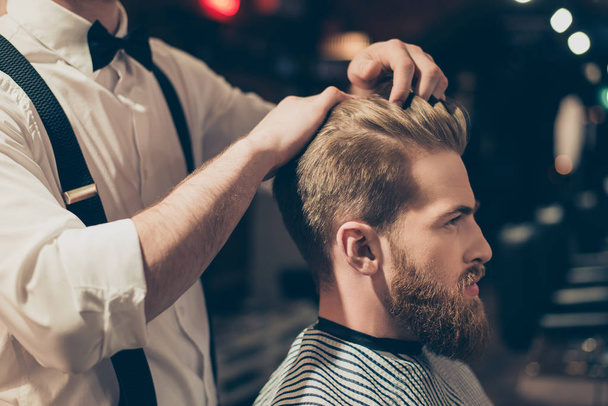 Classy dressed barber shop hairdresser is cleaning client`s neck with a brush and presents his work for him. Stunning! Hairdo looks trendy and so perfect - Фото, зображення
