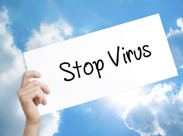 Σταματήσει Virus σημάδι στη Λευκή Βίβλο. Ο άνθρωπος χέρι κρατά χαρτί με κείμενο - Φωτογραφία, εικόνα