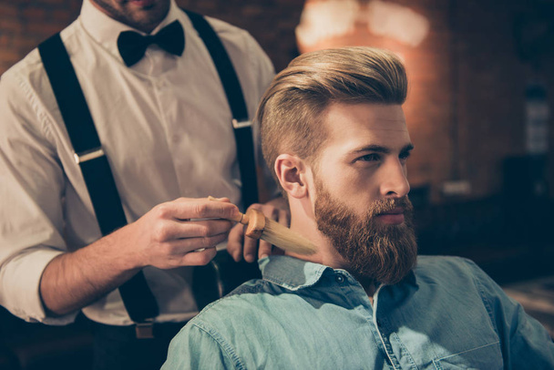 Classy dressed barber shop hairdresser is cleaning client`s neck - Fotó, kép