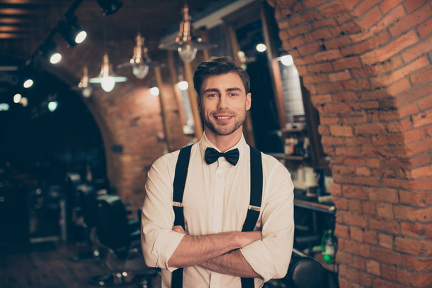 Attractive young brunette bearded guy in a barber shop, standing - Fotó, kép