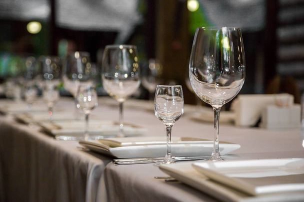 сервировка столового стола с столовым серебром, салфеткой и стеклом в ресторане перед вечеринкой - Фото, изображение