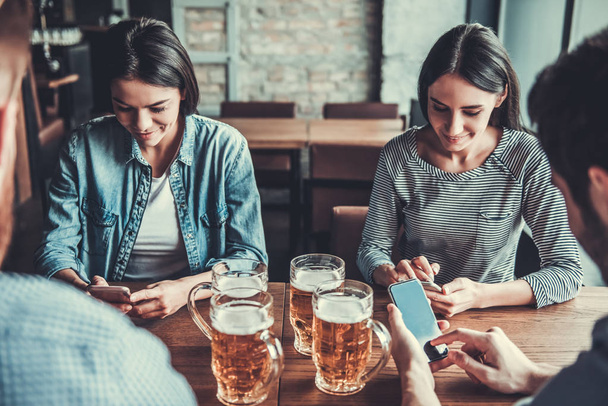 People at pub with phone - Zdjęcie, obraz