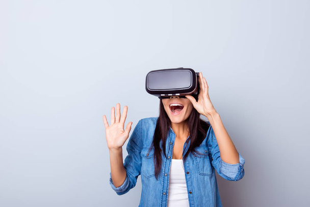 Wow! Excited latinn girl in a VR glasses surprised with what she - Foto, Imagen