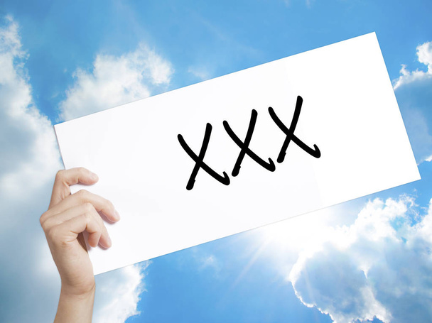 XXX Sign on white paper. Man Hand Holding Paper with text. Isola - Photo, Image