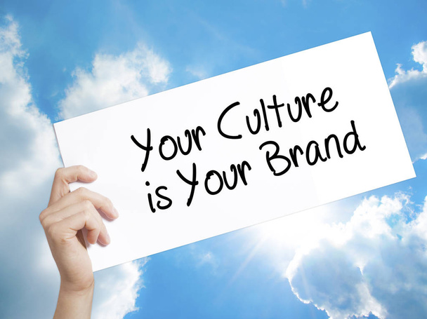 Twoja kultura jest Twój znak marki na białym papierze. Człowiek ręka trzyma - Zdjęcie, obraz