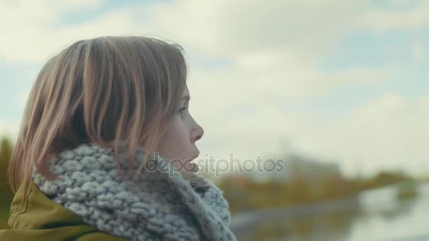 Młoda atrakcyjna kobieta opakowane w ciepłym szalikiem z bliska spacery w parku w chłodnej pogodzie, croons utwór. Zwolnionym tempie - Materiał filmowy, wideo