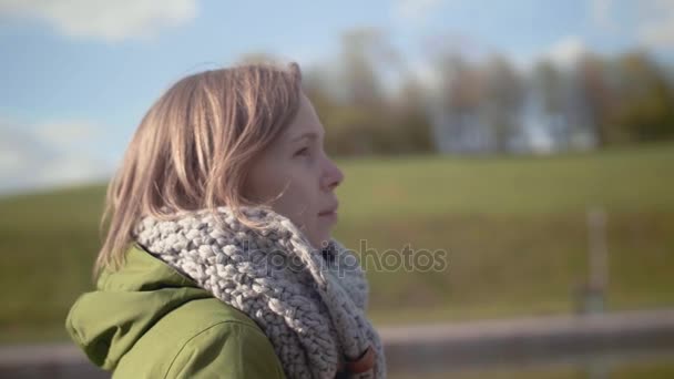 Portret van een jonge en mooie vrouw in een warme sjaal, genieten van een wandeling in het park. Slow Motion - Video