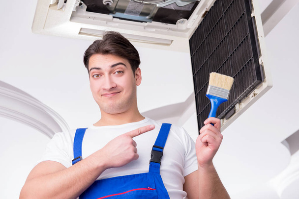 Arbeiter repariert Klimaanlage an der Decke - Foto, Bild