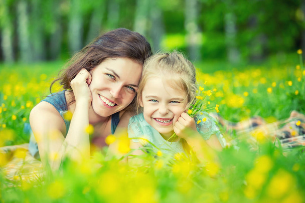 Mother and daughter on sunny meadow - Фото, изображение