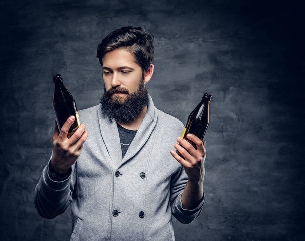 Bearded male holds bottled beer - Photo, Image