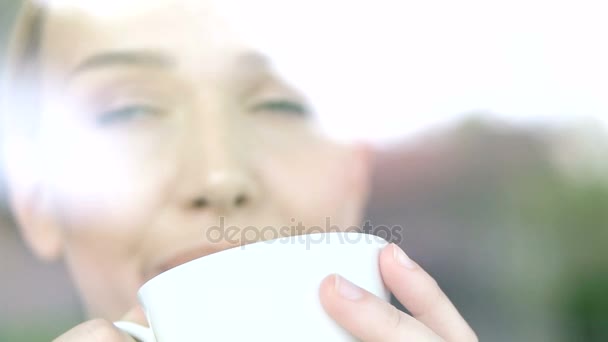 woman drinking a cup of warm tea inside her apartment  - Filmati, video