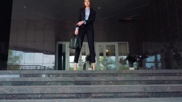 Attractive businessman smiling, she is standing on the top of the stairs - Imágenes, Vídeo