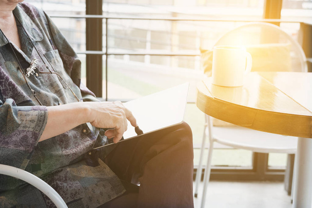 Старшая женщина сидит и отдыхает в кафе кафе с помощью цифр
 - Фото, изображение