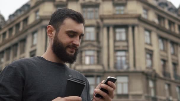 Man checks his Smartphone and drinks coffee - Imágenes, Vídeo