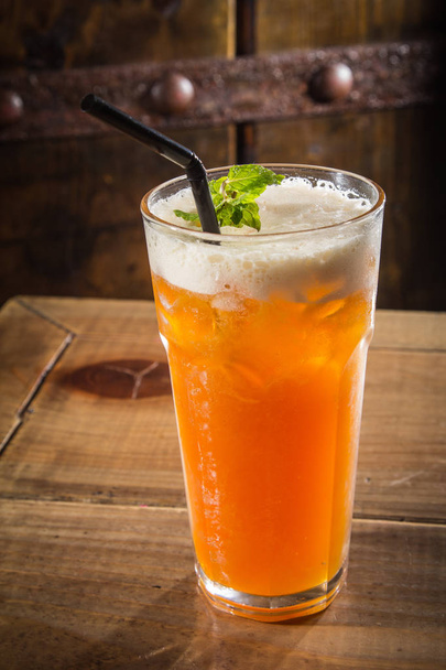 iced cocktail with ice and mint on wooden background - Fotó, kép