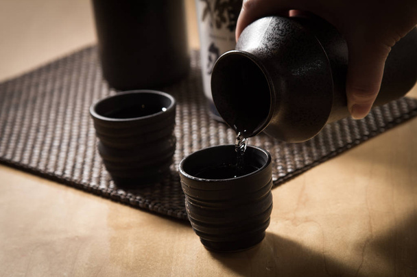 Image of warm sake  on a wooden table - Foto, afbeelding