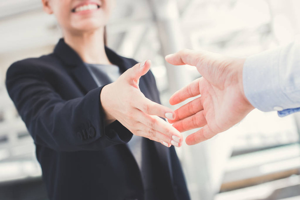 Jovem empresária vai fazer aperto de mão com um homem de negócios
 - Foto, Imagem