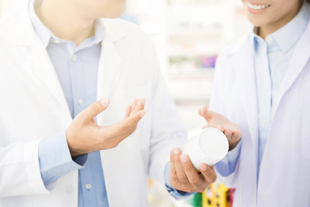 Farmaceuta, trzymając butelkę leku i dyskusji w aptece - Zdjęcie, obraz