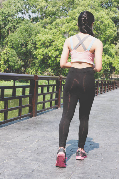 Female sport fitness runner jogging outdoors on bridge in spring - Foto, Imagem