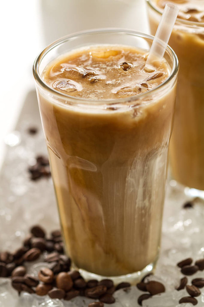 Tasty cold refreshing drink with coffee, milk and ice in glass - Foto, Bild