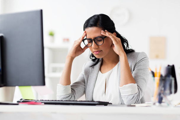 stressed businesswoman with computer at office - Foto, Imagen