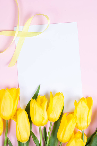 ピンクの背景の美しい新鮮な黄色のチューリップの花束 - 写真・画像
