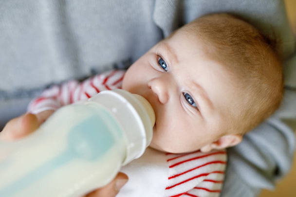 哺乳瓶にミルクで餌の生まれたばかりの赤ちゃん娘を父します。 - 写真・画像
