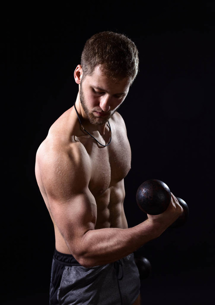 Young bodybuilder with dumbbells - Fotografie, Obrázek