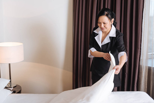 Good looking nice woman making the bed - 写真・画像