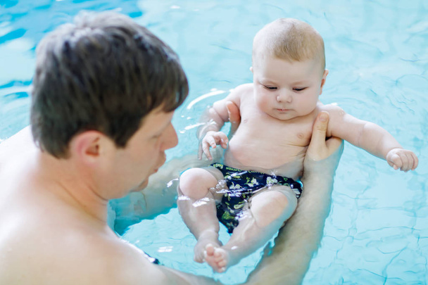 Ευτυχισμένος μεσήλικα πατέρα κολύμπι με χαριτωμένο αξιολάτρευτο μωρό στην πισίνα. - Φωτογραφία, εικόνα