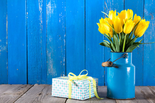 Μπουκέτο με κίτρινες τουλίπες σε βάζο σε μπλε φόντο - Φωτογραφία, εικόνα