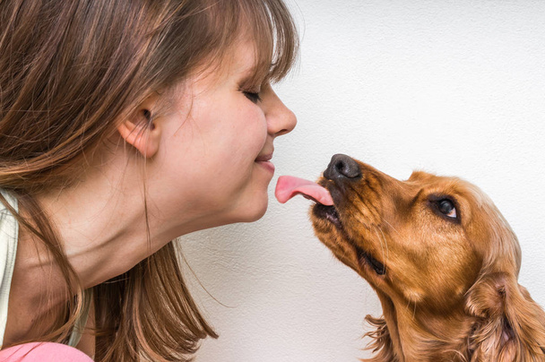 Cute dog licking face of woman - Photo, image