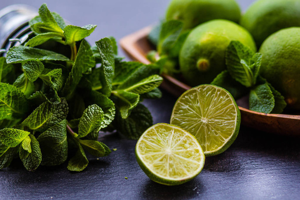 Ingredients fresh mint and lime on a dark background - 写真・画像