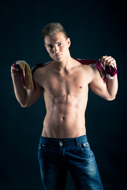 Portrait of confident young man shirtless against black background - Foto, Bild