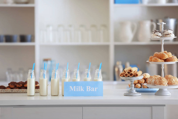 Bottles, desserts and card with text MILK BAR  - 写真・画像