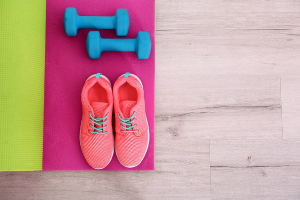 Yoga mat with sneakers and dumbbells   - Foto, Imagen