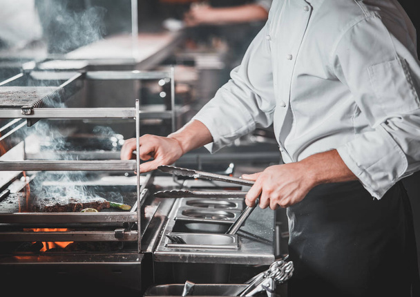 Busy chef at work in the restaurant kitchen - Foto, imagen