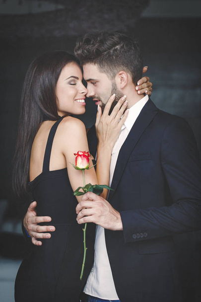 Young rich couple with rose dating indoor - Fotografie, Obrázek